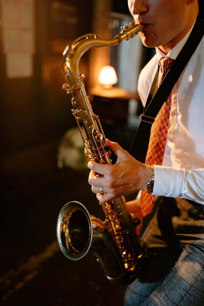 A man plays a saxophone indoors, creating an intimate jazz atmosphere.